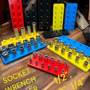 Puede incluir: Un juego de soportes de llaves de vaso de colores con varios tamaños de vasos. Los soportes están etiquetados como "1/2", "3/8" y "1/4". El texto "SOCKET WRENCH HOLDER" está impreso en amarillo sobre una superficie de madera.