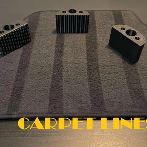 以下が含まれることがあります： グレーのストライプ模様の黒いプラスチック製のカーペットフロアマット3枚。マットは縁が高く、車のカーペットを保護するように設計されています。マットには「CARPET LINES」のラベルが付いています。