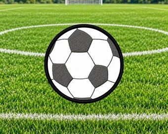 May include: A circular embroidered patch featuring a classic soccer ball design with alternating white and dark gray hexagonal and pentagonal panels, finished with a solid black stitched border around the entire outer edge.