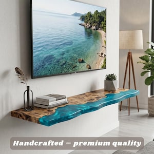 May include: A handcrafted wooden floating shelf with a live edge and a turquoise resin river. The shelf is mounted on a white wall beneath a flat-screen TV. The text "Handcrafted - premium quality" is displayed on the bottom.