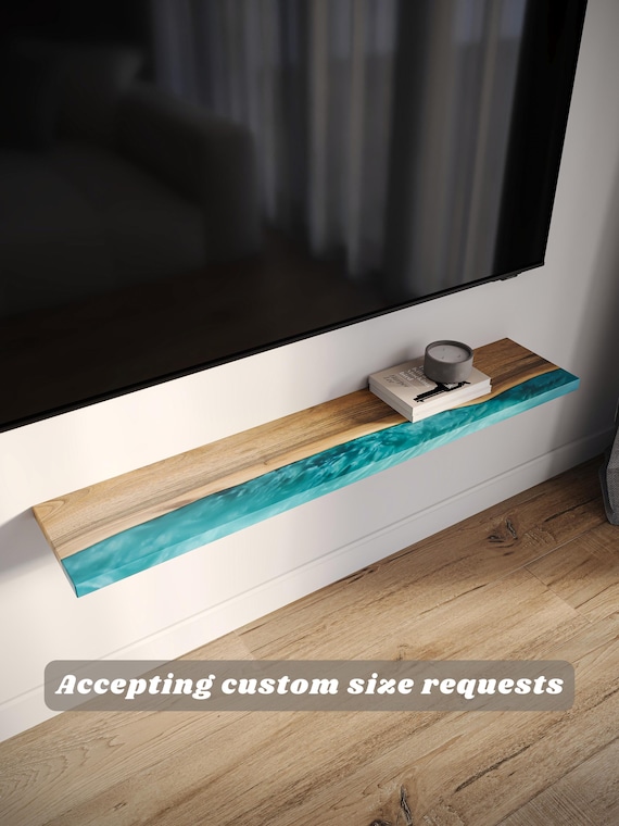 Live edge slab with a vivid epoxy resin fill turned into a floating speaker/book shelf — functional and visually striking at the same time.
