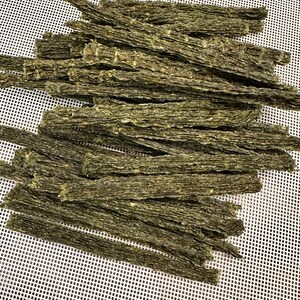 K&ouml;nnte beinhalten: Ein Stapel getrockneter Algensnacks, die auf einer wei&szlig;en Netzfl&auml;che angeordnet sind. Die Snacks sind lang und d&uuml;nn und haben eine dunkelgr&uuml;ne Farbe.