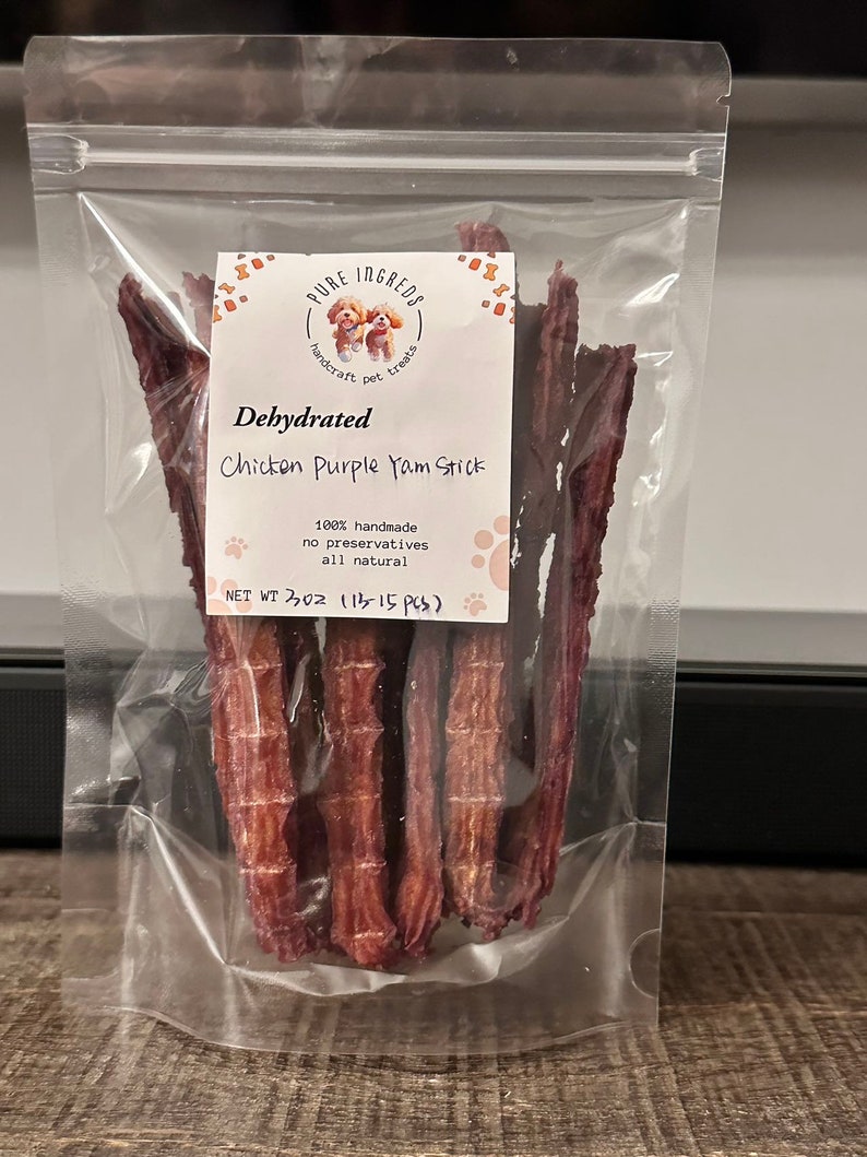 K&ouml;nnte beinhalten: Ein transparenter Plastikbeutel mit dehydrierten H&uuml;hner- und lila S&uuml;&szlig;kartoffel-Hunde-Leckerlis. Der Beutel hat ein Etikett mit der Aufschrift "PURE INGREDS handcraft pet treats Dehydrated Chicken Purple Yam Stick 100% handmade no preservatives all natural NET WT 3 OZ (113-15 PCS)"