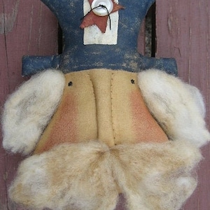 May include: A handmade rag doll with a blue and white hat, a red star, and a button. The doll has a tan body with white cotton for hair and arms.