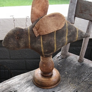 May include: A handcrafted bee figurine with a distressed, vintage aesthetic. The bee features a dark brown body with yellow stripes and tan wings. It is mounted on a wooden stand. The text "Chestnut Junction" is at the bottom.