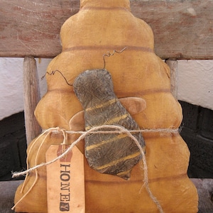 May include: A brown fabric beehive with a bee on top and a tag that says "Honey".