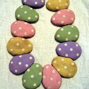 Puede incluir: Una guirnalda de 10 huevos de colores pastel con lunares blancos. Los huevos están dispuestos en círculo y están unidos con una cuerda blanca. La guirnalda es perfecta para decorar para Pascua o la primavera.