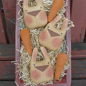 May include: Three brown bunny-shaped stuffed toys with carrot-shaped stuffed toys in a red wooden tray filled with shredded paper. The tray has the text "Chestnut Junction" on the bottom.