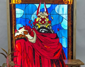 Peut inclure: Une fenêtre en vitrail représentant une figure vêtue de rouge avec une tête de crâne et des cornes. La figure est entourée d'un fond en vitrail bleu et jaune. Le texte "THE ONLY CERTAINTY IS DEATH" est visible sur le côté droit de la fenêtre.