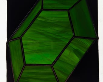 Peut inclure: Une pièce de vitrail vert en forme de gemme multi-facettes. La gemme est placée sur un fond noir.