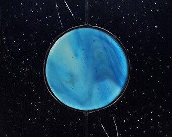 Peut inclure: Une planète bleue avec des tourbillons blancs, entourée d'un fond noir étoilé et d'un anneau blanc.