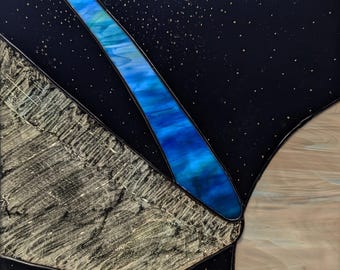 Peut inclure: Œuvre d'art en vitrail abstrait avec une forme incurvée bleue et verte sur un fond noir avec des paillettes dorées. L'œuvre est encadrée et montée sur un panneau de bois.