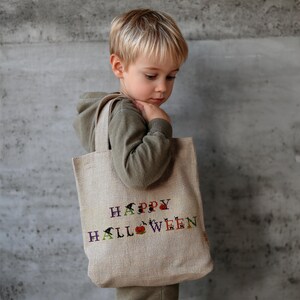 Halloween-themed cross stitch alphabet pattern with spooky decorated letters including pumpkins, witches, ghosts, cats, and bats – digital PDF for instant download
