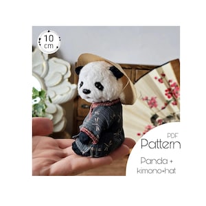 Puede incluir: Patrón PDF para un oso de peluche panda de 10 cm que lleva un kimono y un sombrero. El panda está sentado en una mano.