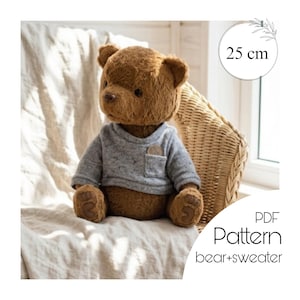 Könnte beinhalten: Ein brauner Teddybär mit einem grauen Pullover mit kleiner Tasche. Der Bär ist 25 cm groß und sitzt auf einer weißen Oberfläche. Das Bild enthält auch den Text "PDF Pattern bear+sweater".