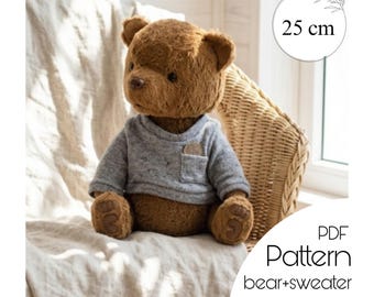 May include: A brown teddy bear wearing a gray sweater with a small pocket. The bear is 25 cm tall and is sitting on a white surface. The image also includes the text "PDF Pattern bear+sweater".