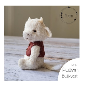 May include: A white plush bull toy with a red vest, sitting on a wooden surface. The toy is 8 inches tall and is part of a PDF pattern for making a bull and vest.