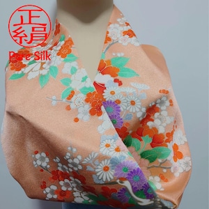 May include: A peach-colored silk scarf with a floral pattern of white, orange, green, and purple flowers. The scarf has the text "正絹 Pure Silk" printed on it.