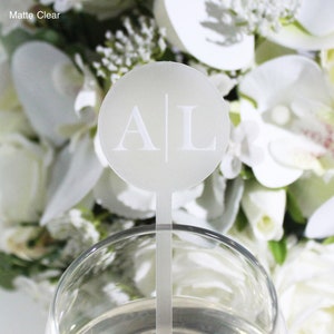 May include: White acrylic drink stirrer with a round, frosted, white disc featuring the initials "A|L" in a simple, sans-serif font.