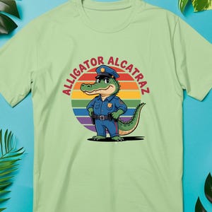 ワニアルカトラズおもしろ警察ワニTシャツ - レトロレインボーサンセットTシャツ、漫画警官ワニシャツ、ユーモアグラフィックTシャツ