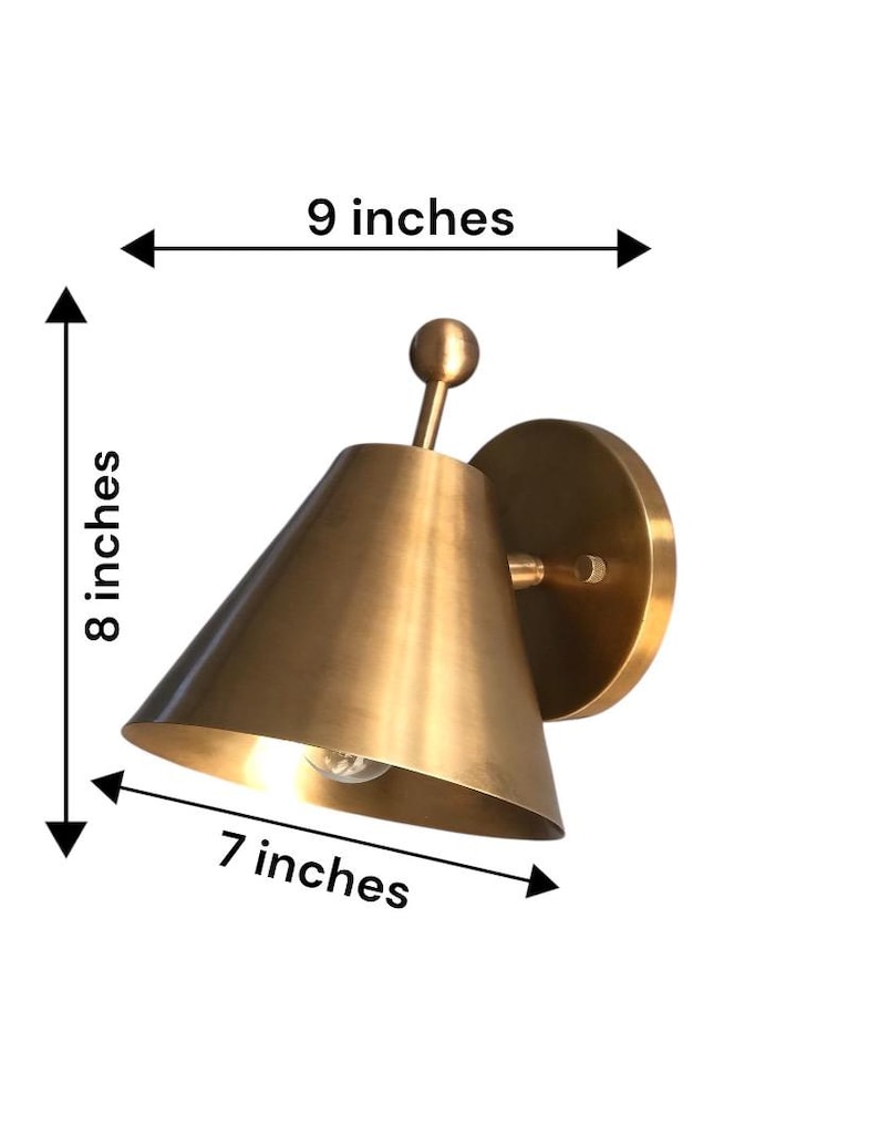 A Traditional Brass Wall Sconce Pair Is Pictured at An Angle, with Both Handcrafted Fixtures Displaying Decorative Finial Accents and Round Wall Canopies. the Matching Solid Brass Forms Create Coordinated Lighting with A Classic Appearance Suited to Vintage and Transitional Interiors, Frost Lights.