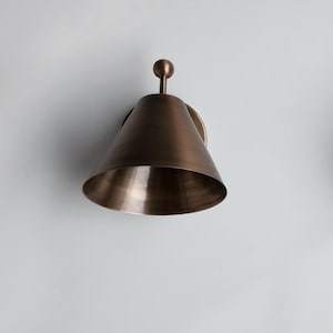 Close View of Two Handcrafted Brass Wall Lights Featuring Decorative Finials and Carefully Finished Solid Brass Surfaces. the Coordinated Pair Has a Classic Vintage Character, with Each Fixture Measuring 7 Inches Wide and 8 Inches High for A Substantial Architectural Wall Presence, Frost Lights.