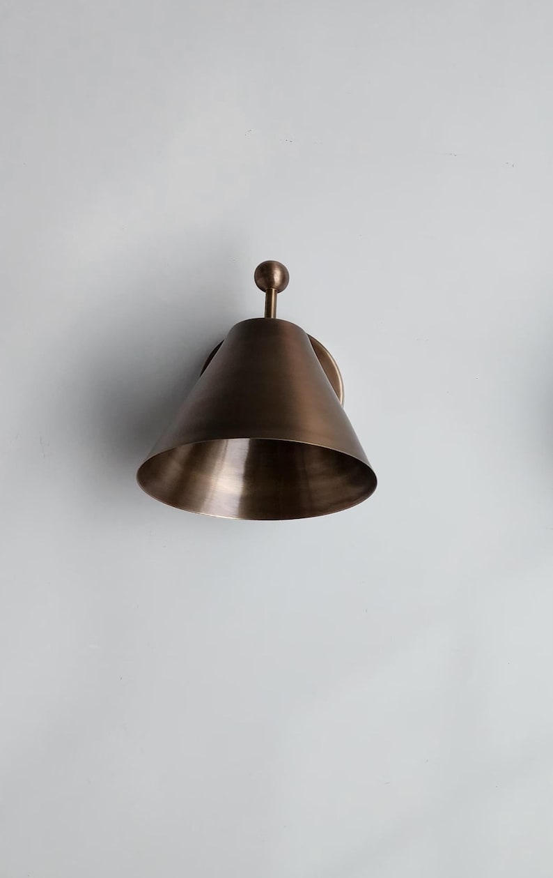 Close View of Two Handcrafted Brass Wall Lights Featuring Decorative Finials and Carefully Finished Solid Brass Surfaces. the Coordinated Pair Has a Classic Vintage Character, with Each Fixture Measuring 7 Inches Wide and 8 Inches High for A Substantial Architectural Wall Presence, Frost Lights.