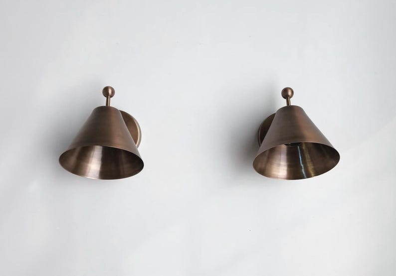 Handcrafted Solid Brass Wall Sconce Pair Featuring Classic Finial Accents and Traditional Decorative Detailing, Shown Together as A Coordinated Set. Each Fixture Has a 7 Inch Width, 8 Inch Height, and 5 Inch Round Canopy with A Warm Vintage Inspired Appearance, Frost Lights.