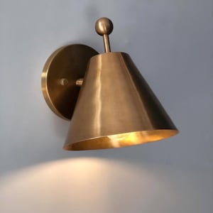 Front Perspective of A Handcrafted Brass Sconce Pair with Elegant Finial Detailing and Round Mounting Canopies. the Traditional Silhouette Combines Solid Brass Craftsmanship with A Warm Metallic Finish, Creating Coordinated Decorative Wall Lighting for Classic and Transitional Interiors, Frost Lights.