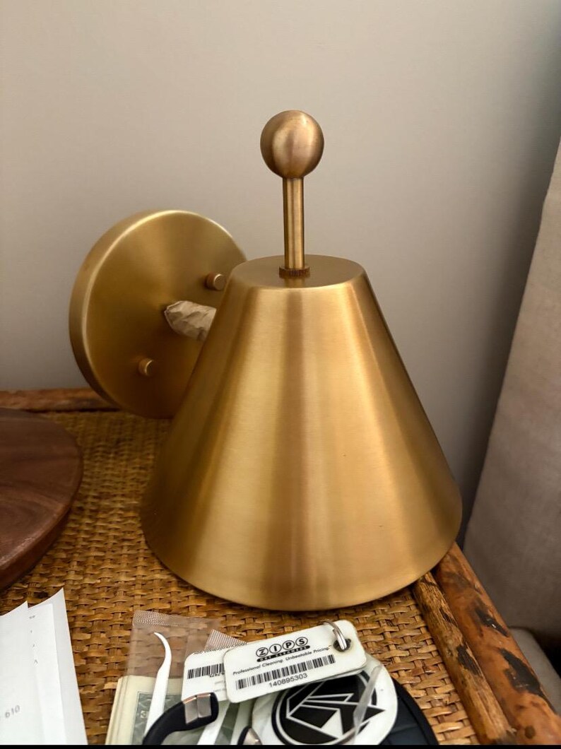 Close Angled Perspective of A Brass Wall Sconce Pair Highlighting the Decorative Finial, Solid Brass Construction, and Traditional Silhouette. the Matching Fixtures Are Designed as A Coordinated Set, Offering a Classic Visual Detail for Bedrooms, Hallways, Entryways, and Living Areas, Frost Lights.