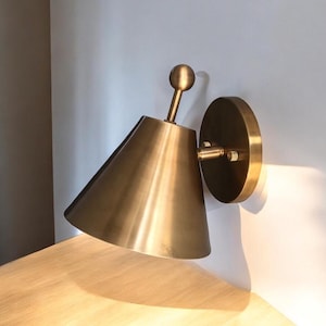 Close-Up of The Carefully Finished Brass Surface and Finial Detailing on A Handcrafted Wall Light from This Coordinated Pair. the Decorative Form Adds Visual Interest to The Classic Silhouette While the Solid Brass Construction Gives the Fixture a Warm Artisan Character, Frost Lights.