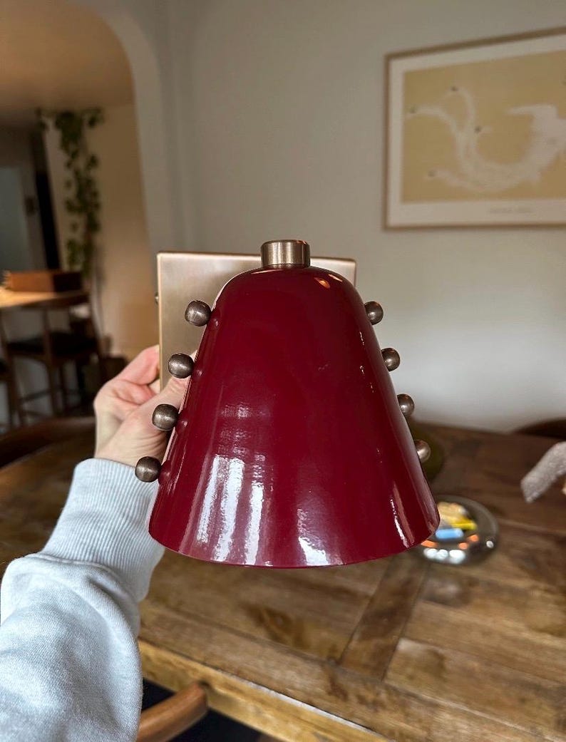 This Handmade Wall Sconce Features a Tapered Wine Shade Mounted to A Brass Structure, Photographed to Show Its Compact Size, Warm Material Contrast, and Understated Decorative Rivet Detailing, Frost Lights.