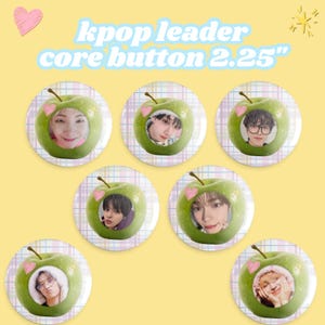 May include: A collection of seven round buttons with a green apple design, each featuring a different person's face. The buttons are labeled "kpop leader core button 2.25" in blue and white text. The background is yellow with decorative hearts and stars.