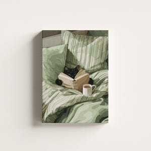 May include: A canvas print depicts a black cat reading a book in bed, surrounded by green pillows and bedding. A white mug of coffee sits nearby. The artwork has a cozy, relaxing theme.