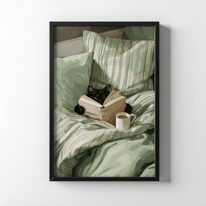 May include: A framed print depicts a black cat reading a book in bed. The cat is nestled among green and white striped pillows and a matching comforter. A white mug of coffee sits nearby. The artwork has a cozy, relaxing theme.