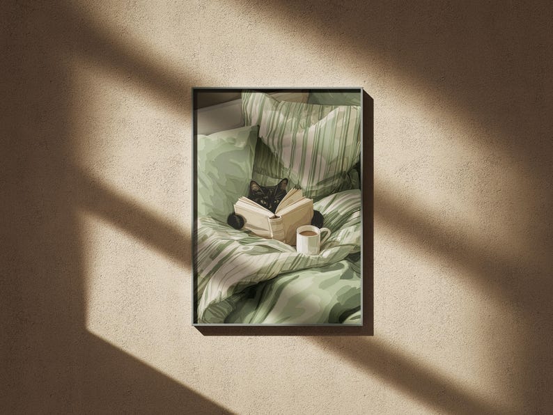 May include: A framed print featuring a black cat reading a book in bed. The cat is nestled among green and white patterned bedding, with a small white mug of coffee nearby. The overall aesthetic is cozy and inviting.