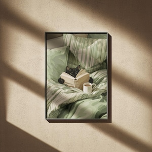May include: A framed print shows a black cat reading a book in bed. The cat is surrounded by green and white bedding, with a cup of coffee nearby. The print is displayed on a beige wall, with shadows cast across the surface.