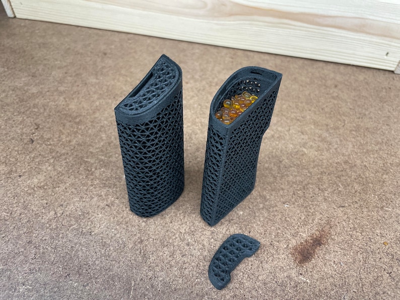 May include: Three black 3D printed containers, one with a removable lid and one filled with small yellow beads.
