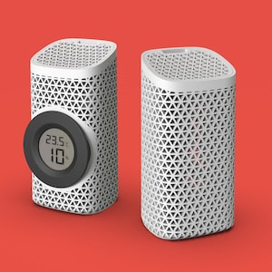 May include: Two white cylindrical devices with a honeycomb pattern. The device on the left has a black circular display showing a temperature of 23.5 degrees Celsius and a humidity of 10%.
