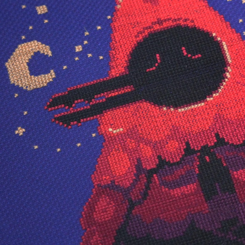 May include: A red and black pixel art cross-stitch design of a spaceship flying through a starry night sky. The spaceship has a round, black cockpit with two small windows and a long, black wing.