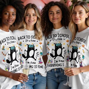 May include: Four women wearing white t-shirts with a black cat graphic and the text "BACK TO SCHOOL It's fine. I'm fine EVERYTHING IS FINE." The women are holding champagne flutes.