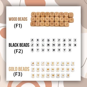 May include: A display of alphabet beads in three different styles: wood, black, and gold. The wood beads are a natural color, the black beads have white lettering, and the gold beads have gold lettering. Each set of beads is arranged in alphabetical order.