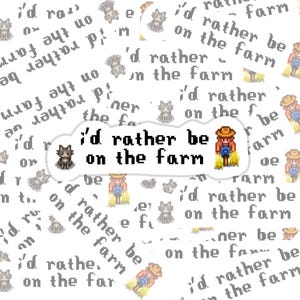 May include: White sticker with the text "I'd rather be on the farm" in a black, pixelated font. The sticker features pixel art of a farmer, a cat, and the phrase "I'd rather be on the farm" repeated.