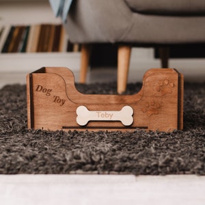 May include: A wooden dog bed with the words "Dog Toy" and a bone-shaped name tag that says "Toby".