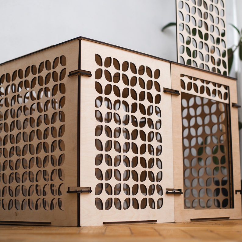 May include: A wooden box with a geometric pattern cut out design. The box is made of light wood and has a square shape.