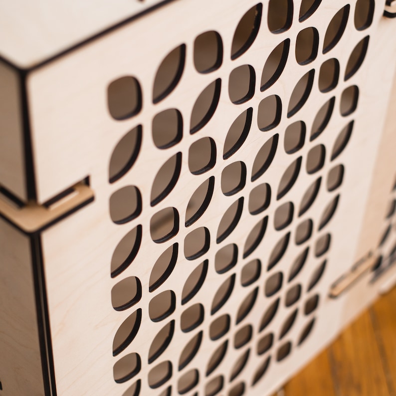 May include: A wooden box with a geometric pattern cut out of the front. The pattern is made up of small, oval shapes that are arranged in a repeating pattern.