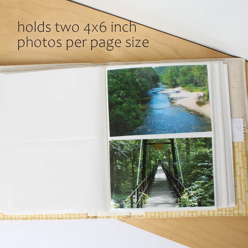 Puede incluir: Un &aacute;lbum de fotos blanco con una cubierta de patr&oacute;n amarillo y blanco. El &aacute;lbum est&aacute; abierto en una p&aacute;gina con dos fotos de 10x15 cm de un r&iacute;o y un puente colgante.