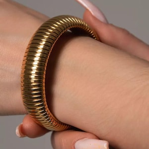 Op de afbeelding: Een gouden slangenketting armband met een flexibel ontwerp.