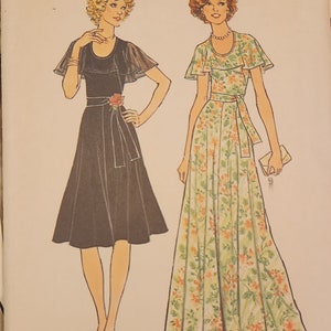 May include: A sewing pattern for two dresses. The first dress is black with a ruffled neckline and a sash. The second dress is a long floral print dress with a ruffled neckline and a sash. The pattern is for size 12, bust 34 inches, and is for misses.