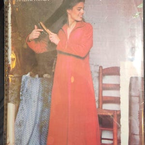 May include: Vintage sewing pattern titled "See & Sew" by Butterick. The pattern features a woman wearing a long, red robe. The pattern size is Large 16-18. The image is a retro style.